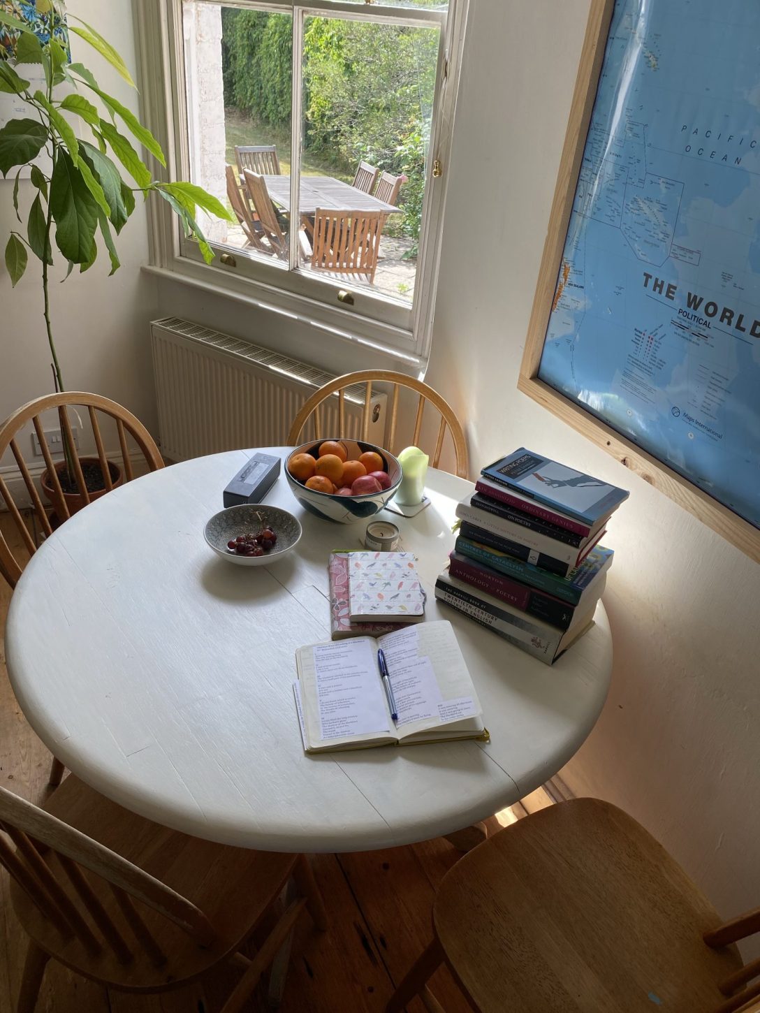 A table containing a pile of poetry books and an open notebook with a pen.